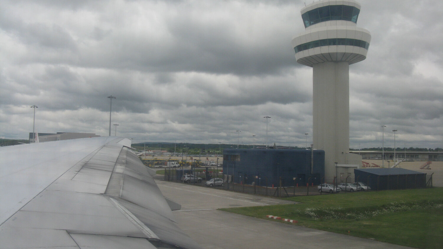 Gatwick Airport air traffic control tower beside an aircraft wing.