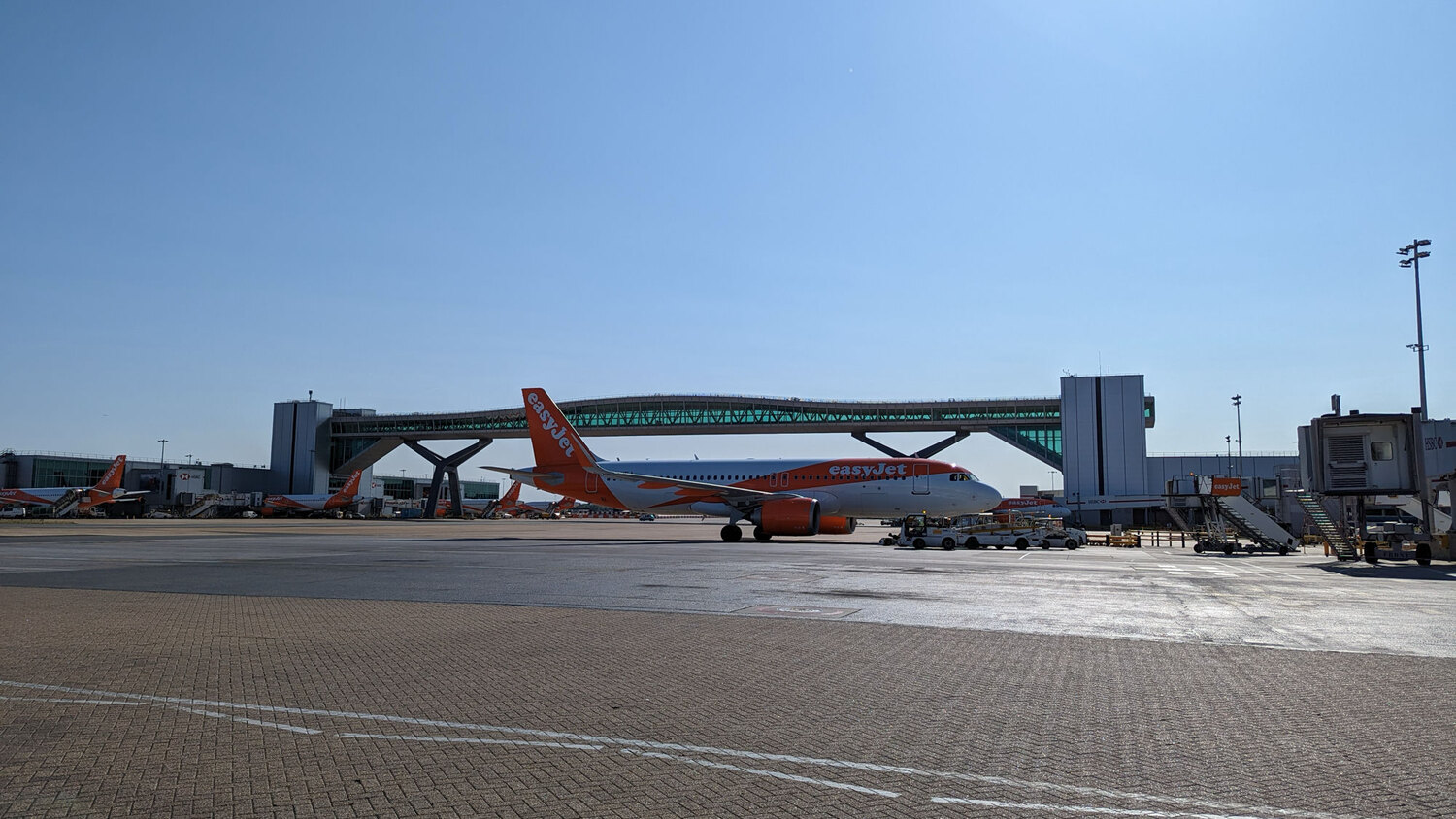 Aircraft and ground vehicles operating on the apron at Gatwick Airport.